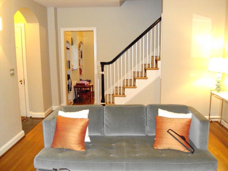 Neutral Living Area With Bare Walls and Plain Gray Sofa