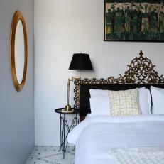 White Bedroom With Gold Mirror, Ornate Headboard & Moroccan Rug