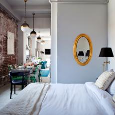Small White Bedroom Features Gold Mirror, Ornate Headboard