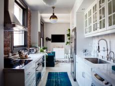 White Galley Kitchen With Teal Runner Leading to Living Room