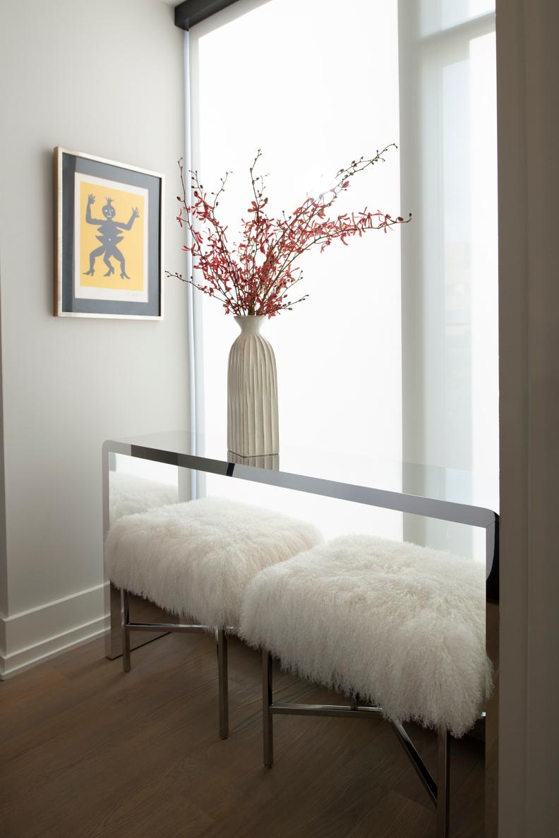 White Sheepskin Stools Under Modern Lucite Console Table