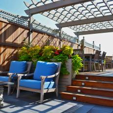 Rooftop Deck With Wood Pergola and Blue-Cushioned Chairs