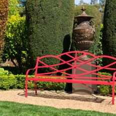 Garden with Eclectic Red Bench and Oversize Metal Artwork 