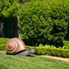 Eclectic Garden Featuring a Large Snail Sculpture 