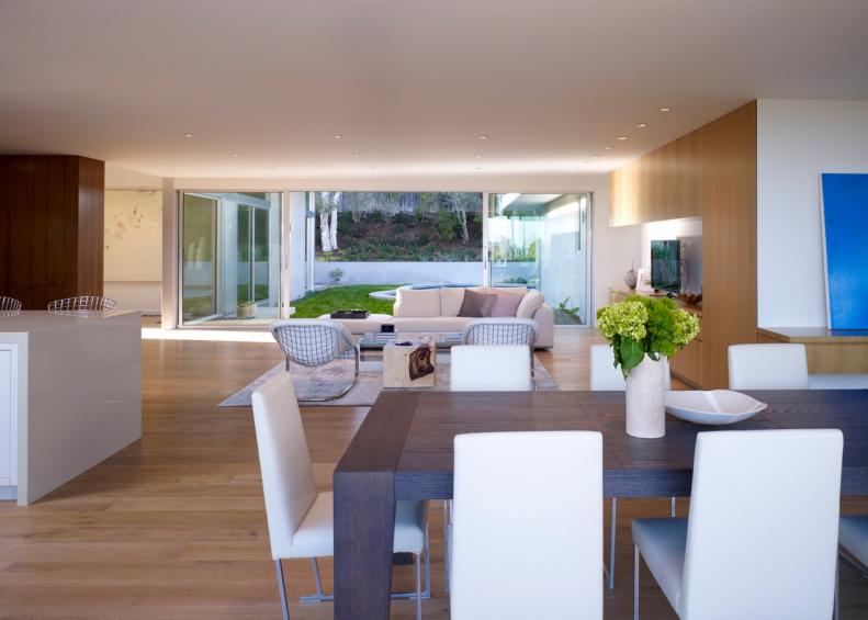 White Modern Dining Space With Dark Wood Table and White Chairs