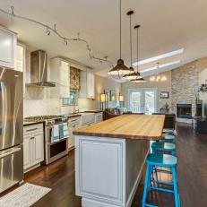 Charming Open Plan Kitchen With Breakfast Bar and Teal Barstools