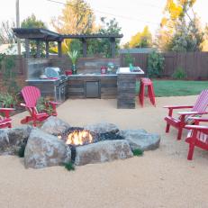 Rugged Fire Pit With Red Adirondack Chairs 