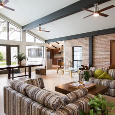 Spacious Modern Living Space With Vaulted Ceiling and Brick Wall