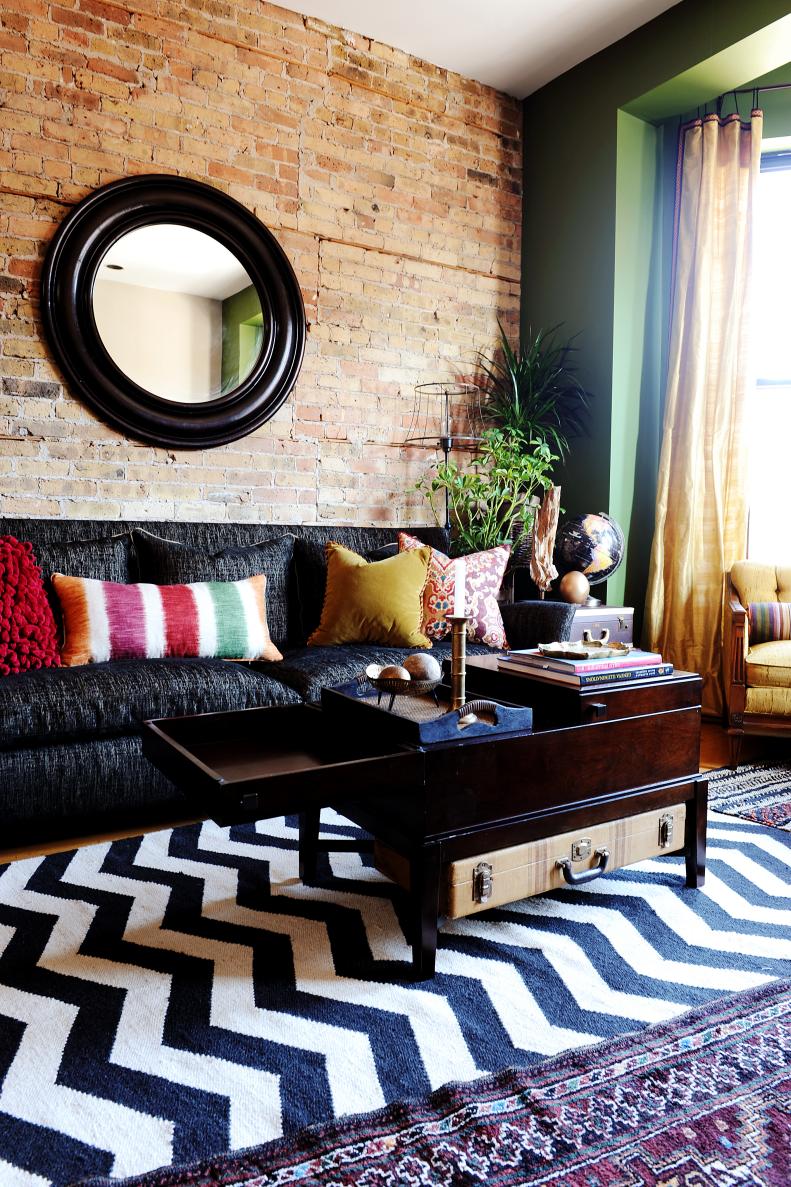 Eclectic Living Space With Black and White Chevron Rug and Brick Wall