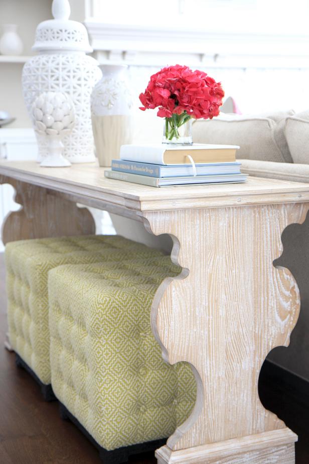 Neutral Wood Console With Pink Flowers and Tufted Green Ottomans
