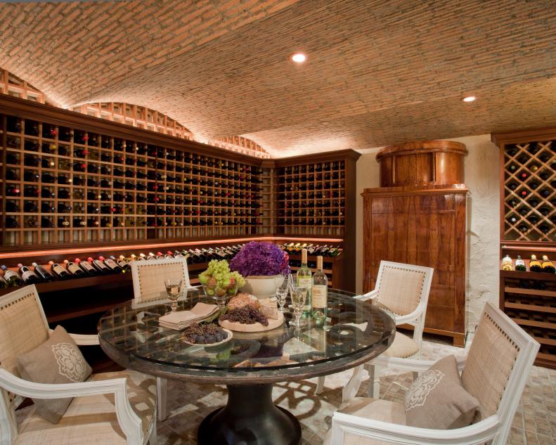 Mediterranean Wine Cellar With Exposed Brick Ceiling and Dining Table