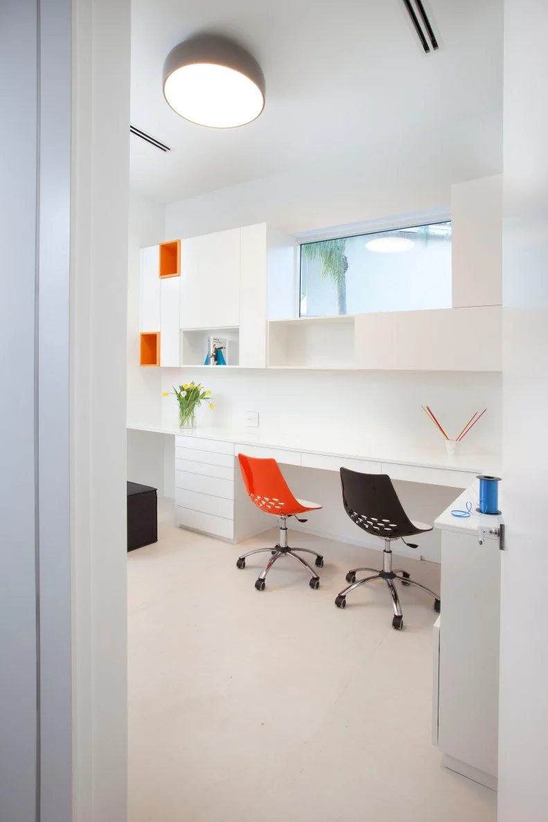 White Modern Home Office With Black and Orange Roller Chairs