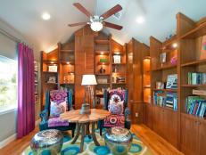 Colorful library with impressive built-ins that meet a vaulted ceiling