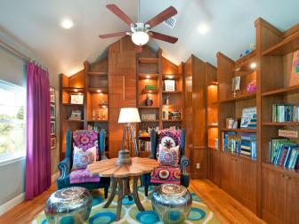 Colorful library with impressive built-ins that meet a vaulted ceiling