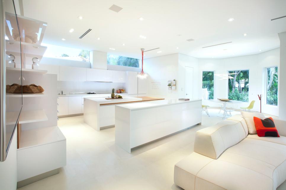 Ultra-modern, all-white kitchen opens to a living area