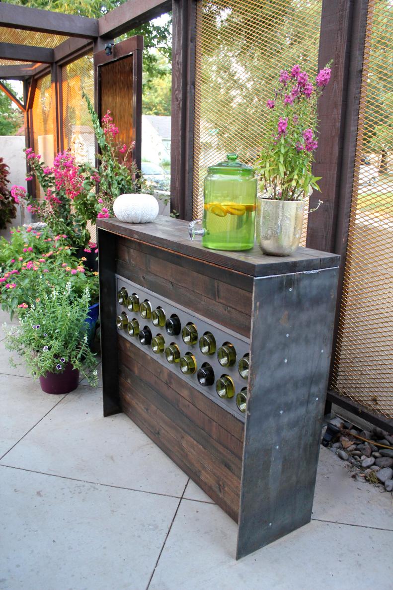 Lush potted plants surround a unique sideboard on a patio courtyard 