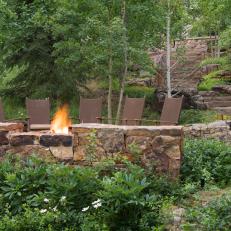 Fire Pit Framed by Rugged Stone Retaining Wall