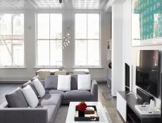 White Modern Loft Living Space With Gray Sofa and Tin Ceiling