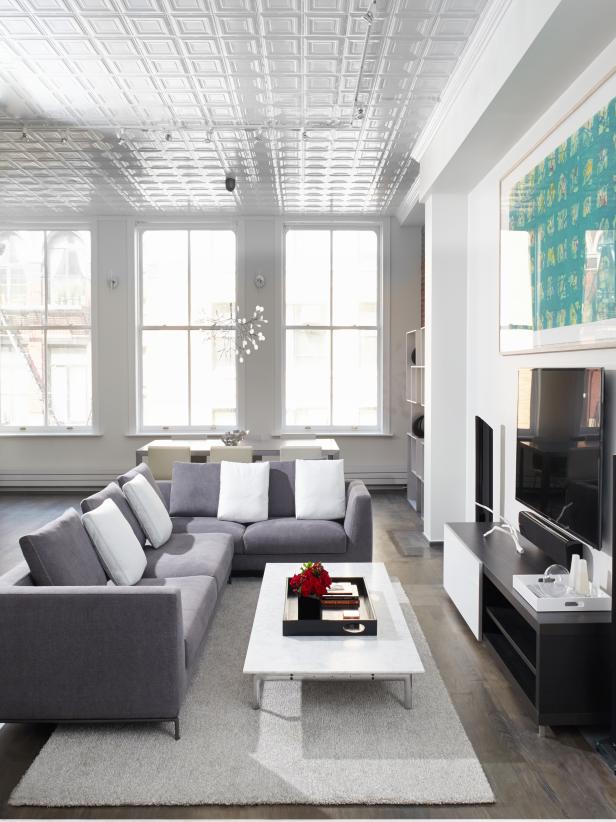 White Modern Loft Living Space With Gray Sofa and Tin Ceiling