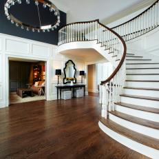 Foyer With Spiral Wood Staircase and Large Chandelier