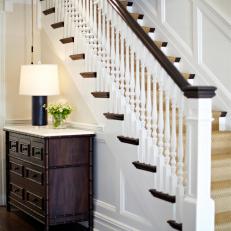 Traditional Foyer With Wood Stairs and Bamboo Dresser