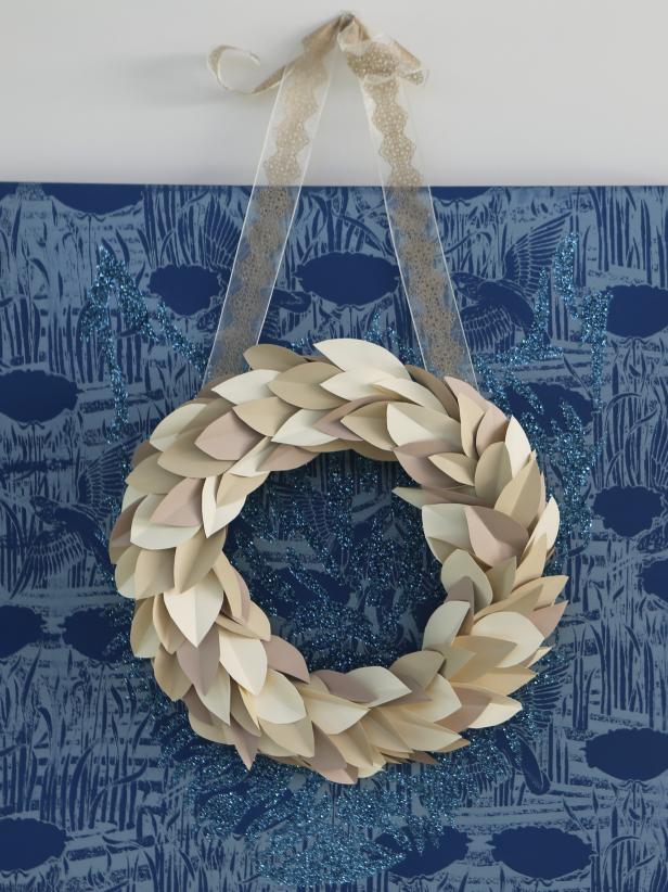 This contemporary paper wreath is a modern take on the classic magnolia-leaf wreaths often seen around the holidays. Making a paper version ensures it will last all winter long when hung indoors.