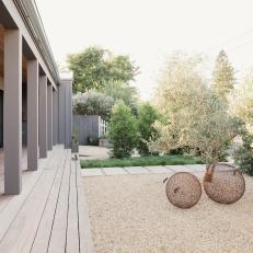 Gravel Courtyard With Gray Deck and Globe Sculptures