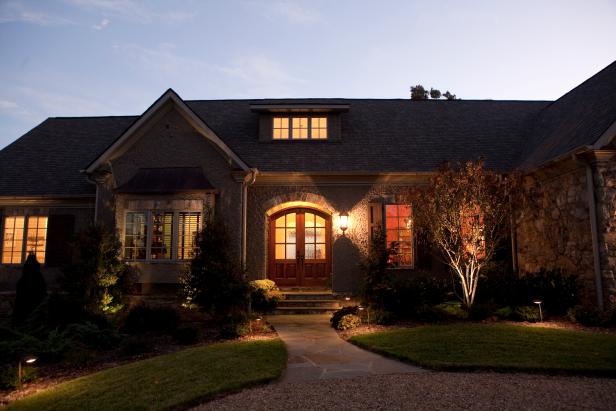 Stone Home Exterior and Flagstone Walkway at Night | HGTV