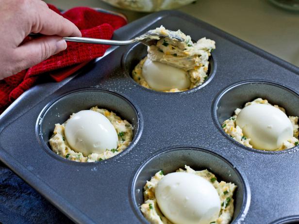 Cover eggs with second layer of batter to make an easy cheddar chive muffin breakfast for overnight holiday guests.