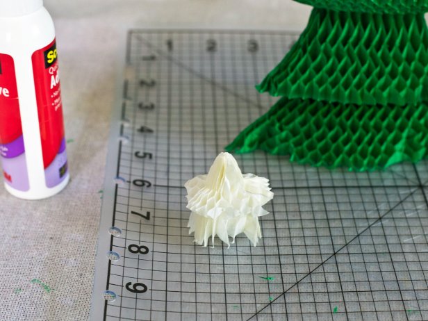 Fan out star-shaped honeycomb paper for a Christmas tree topper for a holiday centerpiece.