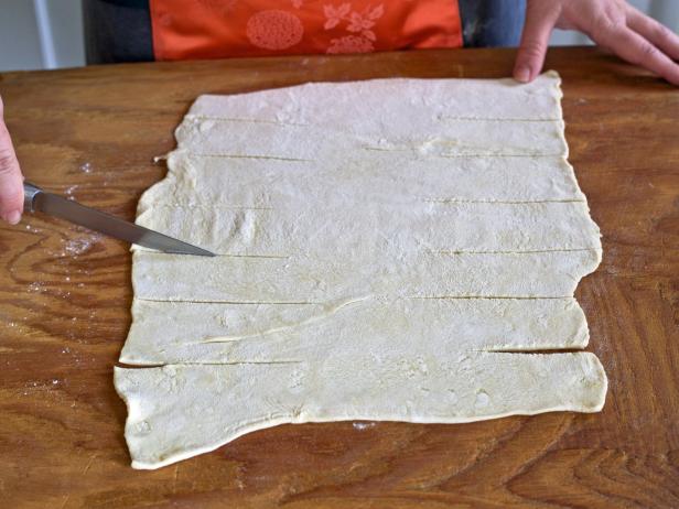 Cut dough into strips to make a cheese and herb pastry for holiday guests.