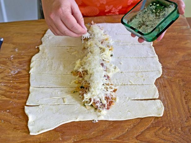 Top dough with cheese and herbs to make a wreath pastry for holiday guests.