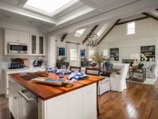A mix of marble and butcher block countertops combined with keen craftsmanship and high-end appliances anchors this Cape Cod-style kitchen.