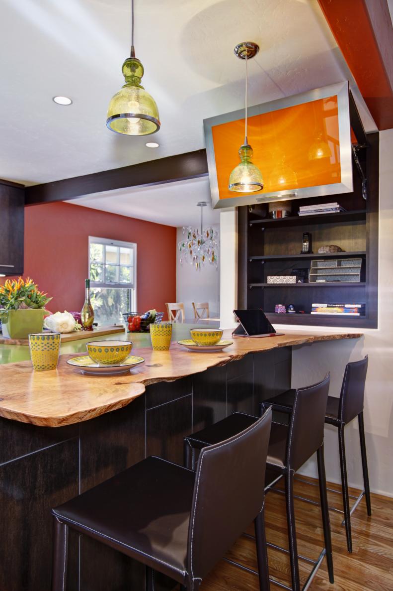 Neutral and Orange Kitchen With Island and Brown Barstools