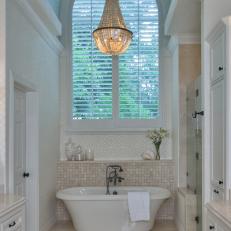 Luxe Primary Bathroom With Bathtub and Chandelier