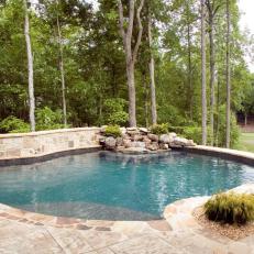 Swimming Pool With Rustic Waterfall and Stone Retaining Wall
