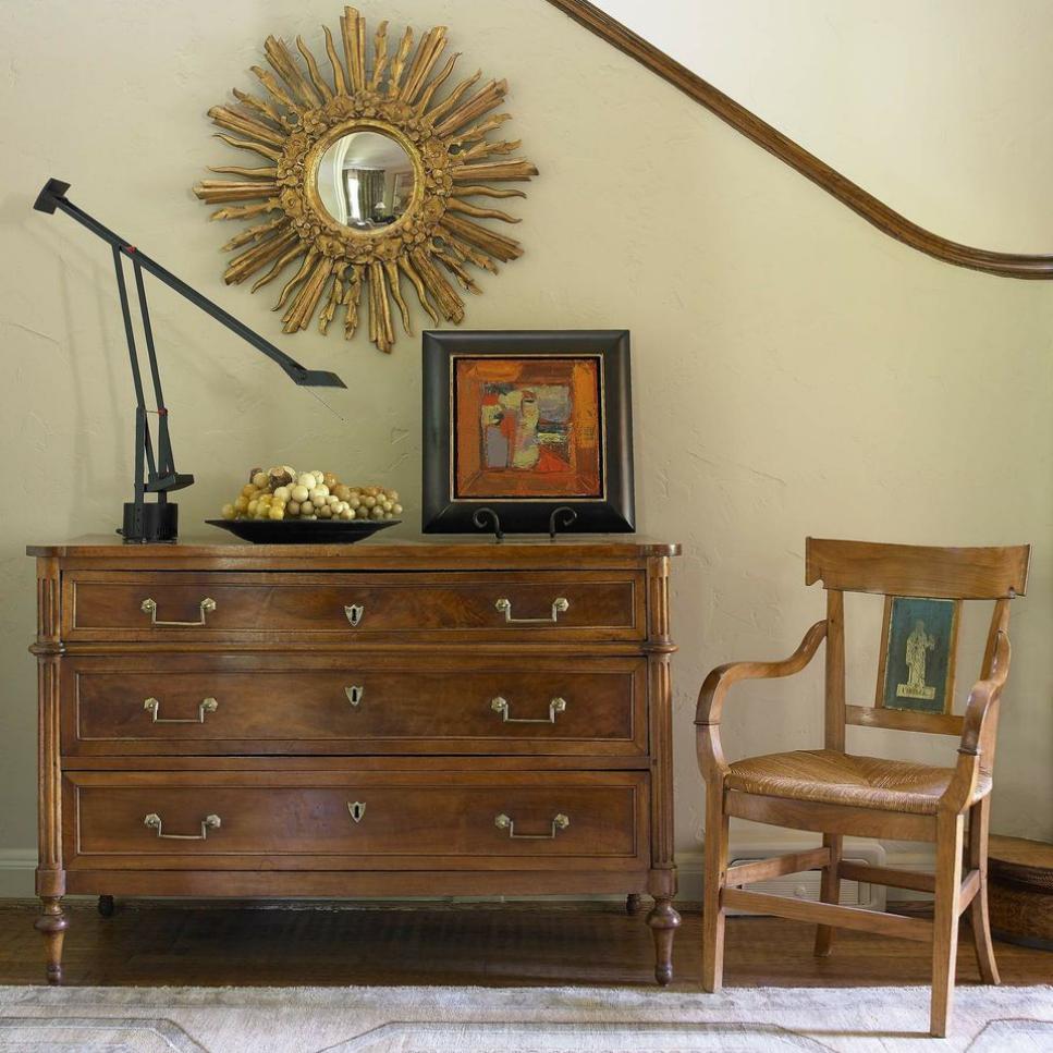 Neutral Transitional Hallway With Gold Mirror, Chair and Dresser