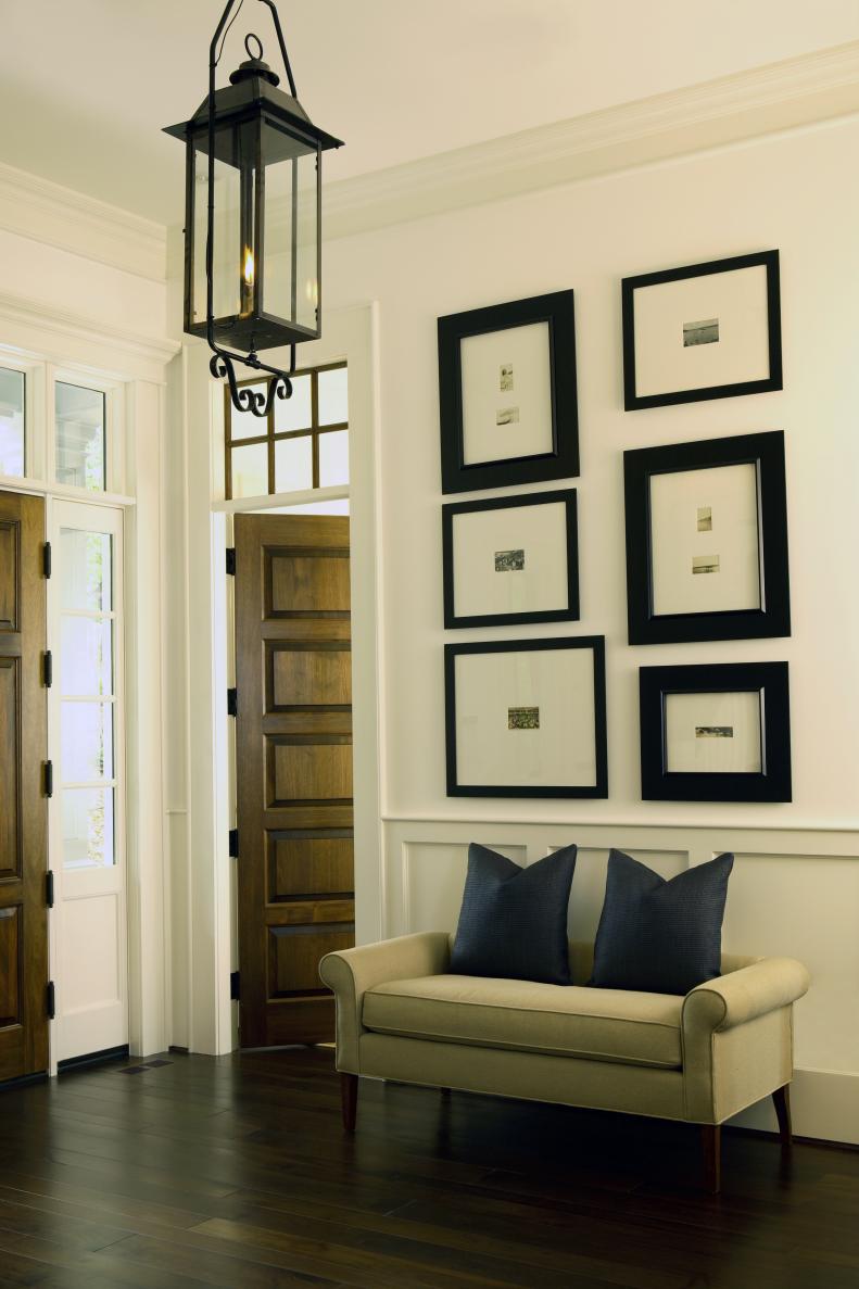 White Foyer With Gallery Wall, Black Lantern & Neutral Settee 