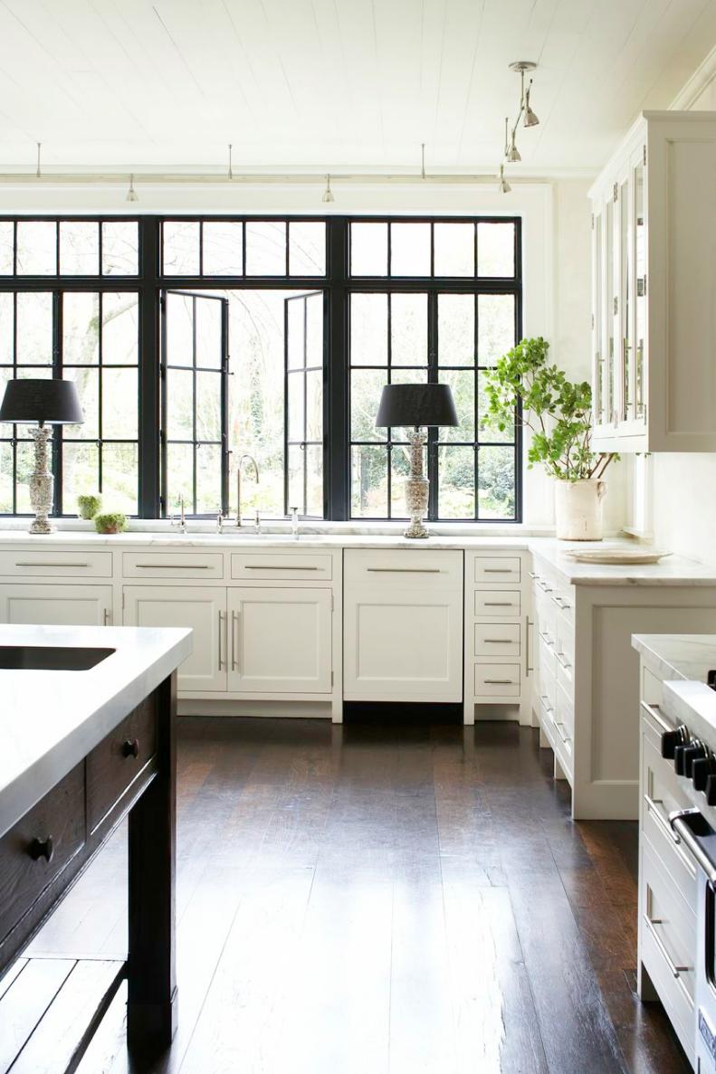 Kitchen With White Cabinets, Black Paned Windows and Hardwood Floors