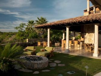 Mediterranean Home Exterior With Stone Patio, Grassy Area & Fire Pit