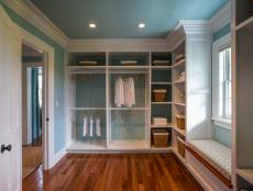 Soft blue walls and sophisticated white crown molding blend seamlessly to give this luxurious master closet a show-stopping finish.