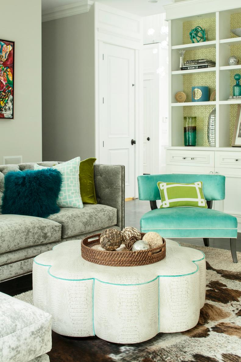 Cream Scalloped Ottoman and Blue Chair in Gray Family Room