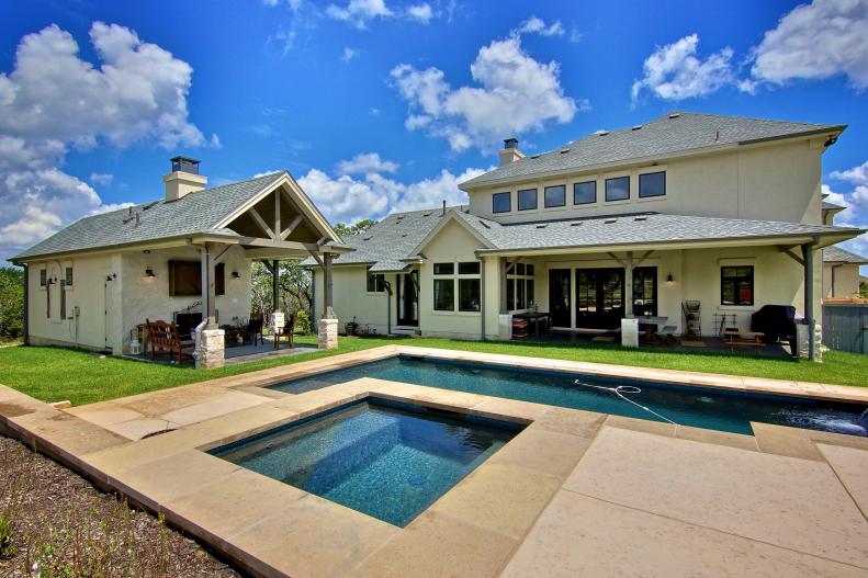 French Country Home's Backyard With Lap Pool and Detached Garage