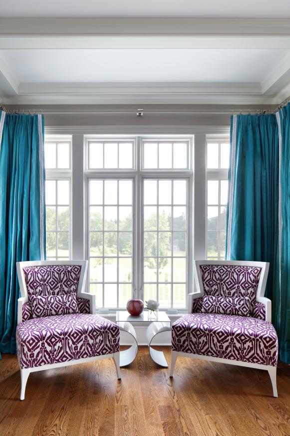 Light Gray Sitting Room With Blue Curtains and Purple Patterned Chairs