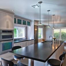 Contemporary Kitchen With Large Island and Black Countertops