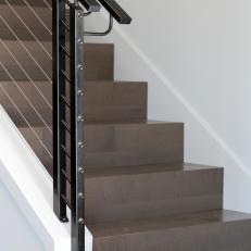 Sleek Modern Staircase With Steel Cable Railing and Black Handrails 