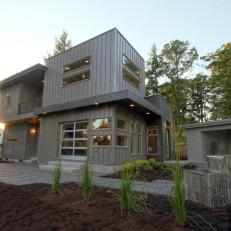 Exterior View of Modern Gray Home With Stone Walkway Through Garden 