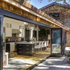 Exterior Deck View of Contemporary Kitchen With Glass Doors and Large Island