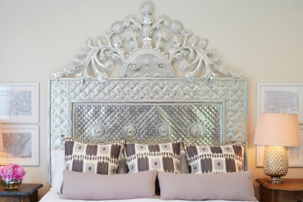 Off-White Bedroom With Intricate Silver Headboard and Purple Pillows