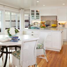 Open, Airy Coastal Kitchen Features White Cabinetry & Wicker Chairs 